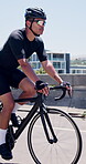 Athlete, man and cycling on bicycle in city for cardio exercise, endurance challenge and fitness. Bridge, cyclist and riding bike in road for triathlon training, sports performance and race workout