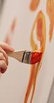 Artist, hands or stroke with paint brush on canvas for artwork, drawing or creative design. Closeup, person or painter with orange color, creativity or tools for art project, artistic skill or talent