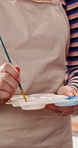 Creative, painting and hands with brush, color and person with talent for artwork, artist and hobby. Painter, process and skill development with tool for project, craft or sketch with palette in home
