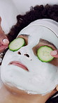 Cucumber, facial and skincare with woman at spa for salon treatment, pore detox and self care. Clay face mask, dermatology and beauty cosmetics with above of person in resort for glow and shine