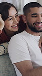Hug, happy and couple on sofa in home with online joke for bonding, relationship and love. Apartment, dating and man with woman on tech for social media, connection and relax together on weekend