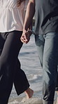 Holding hands, happy and couple on beach for walking on holiday, getaway and summer vacation. Dating, nature and man with woman by ocean for relationship, connection and relax outdoor with waves