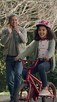 Happy girl, grandparent and help with bicycle ride in neighborhood for support or learning. Child, kid or cycling with helpful grandpa, smile or proud moment for adventure or outdoor journey on road