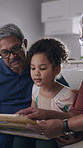 Child, grandparents and reading book at house for education, fantasy story and bonding together. Smile, kid and listening to old people for storytelling, literature learning and language development