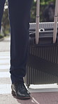Businessman, feet and walking in city with suitcase, travel and commute for professional work trip. Person, shoes and morning journey outdoor in urban town with luggage, mission and job opportunity.