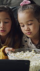Popcorn, tablet and children in home for watching tv, movie or series together on weekend. Technology, happy and girl kids eating snack for streaming film with subscription in living room at house.