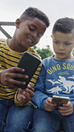 Children, friends and phone with connection, app or data share for anti social behaviour at park. Group, kids or youth typing with mobile smartphone for research, media or network on playground