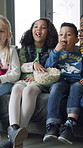 Popcorn, watching tv and kids laugh in home, streaming show or comedy movie on weekend. Television, boys and girls eating snack in living room with friends, entertainment and funny cartoon for relax