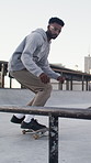 Man, city and action with skateboard for grind on rail with trick, training and jump for sports. African person, skateboarder and leap for stunt at skatepark, exercise and hobby with balance outdoor