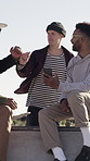 Skateboard, friends and men fist bump for welcome, show phone and conversation outdoor. Smile, skateboarder and group at skatepark with greeting on ramp, mobile and post trick on social media