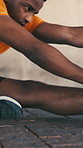 Fitness, legs and stretching with black man outdoor for preparation or start of cardio workout. Exercise, training and warm up with African runner on ground in city for balance, challenge or health