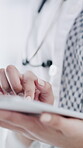 Hospital, doctor and hands with tablet, typing or research for diagnosis with patient records on web. Healthcare worker, online and person with tech for treatment plan, medicine and medical report