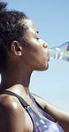 Fitness, tired woman and drinking water outdoor for wellness, health and smile on break with sweat. African person, exercise and athlete with bottle for hydration, nutrition and workout recovery