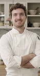 Man, chef and face with arms crossed in kitchen for confidence, smile and career at restaurant. Person, happy and pride for cuisine, portrait or culinary job for catering at diner in New Zealand