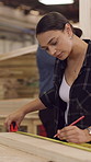 Carpentry, workshop and woman with measuring tape for furniture, dimensions and wood design. Factory, carpenter and person with measurement for planning, repair and woodworking for timber project