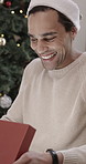 Christmas, excited and man in home with gift for surprise at xmas party, event and social gathering. December, happy and person with box excited for tradition, festive season and holiday with present
