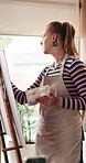 Painting, woman and easel in home studio for creative project, visual expression and creation for craft. Passion, canvas and artist with inspiration for activity, brush and talent for passion project