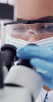 Microscope, woman or scientist in lab for biology, cancer research and cure development with ppe. Science, face mask and person with microbiology equipment, medical pathology or analysis for oncology