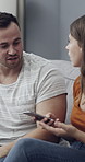 Cellphone, angry and couple with argument on sofa in living room for divorce, affair or breakup. Phone, upset and man with woman, fighting and text for online infidelity on dating app in home