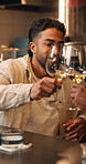 Cheers, wine and man in restaurant with date for bonding, connection or romantic celebration. Toast, drinking and person with alcohol beverage for anniversary for commitment with hospitality at night