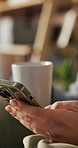 Hands, woman and coffee with phone at house for social media, dating app and texting. Female person, beverage or mobile for communication, reading ebook and chatting with match notification in lounge