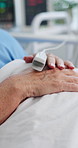 Hands, person and oximeter in hospital for recovery, monitor and surgery treatment. Healthcare, mature patient and pulse meter in clinic for heart rate, oxygen track and tech for post operation