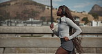 Running, headphones and black woman in city for fitness,  cardio health and endurance training. Workout, jog and person streaming music for exercise, wellness and listening to audio on bridge outdoor