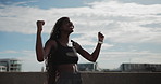 Fist pump, success and watch with woman runner outdoor on bridge for achievement or milestone. Blue sky, exercise and time with happy athlete in celebration of fitness, running or training goals