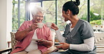 Laughing, old woman and caregiver with coffee, cheers or bonding on break, healthcare and discussion. Homecare, nurse and senior person with tea in lounge, flare and funny joke with elderly patient