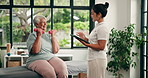Senior woman, physiotherapist and dumbbells with tablet for injury recovery at wellness clinic. People, exercise and weightlifting for rehabilitation, smile or app for elderly patient in retirement
