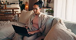 Woman, student and laptop on sofa in home for online learning, typing and university portal for assignment. Female person, education and study with elearning forum, chat or writing thesis at house