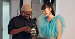 Man, photographer and talking to model with camera, review pictures and results of photoshoot. People, discussion and check equipment for photography, feedback and pose guidance for fashion magazine