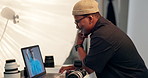 Photographer, man and editing in studio with laptop, retouching image or picture for fashion magazine. Happy, black person or cameraman in workplace with computer, color grading or check photography.