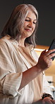 Happy, typing and woman in kitchen, smartphone for texting and digital app for social media. Home, laughing and mature person with online reading, smile or cellphone for connection and communication