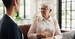 Healthcare, stomach or wellness with nurse and old woman on sofa in home for feedback or review. Conversation, indigestion or visit with caregiver and senior patient in apartment for assisted living