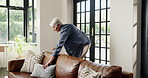 Tidy, cushion and senior woman in lounge for spring cleaning, wellness and chores. Pensioner, apartment and elderly person in living room, housekeeping and furniture decoration to prepare for viewing