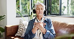 Senior, calm and woman with headphones on sofa for audio therapy, sound or peaceful tune in home. Elderly, female person or relax with breathing exercise for stress relief music or mental wellbeing