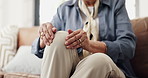 Hands, massage and knee pain with old person on sofa in living room for arthritis or osteoporosis. Inflammation, joint injury and rubbing with senior woman in home for recovery or rehabilitation