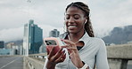 Black woman, runner and phone on bridge for texting with fitness, music and earphones in city. African person, smile and smartphone on mobile app, streaming or chat on break for exercise in town