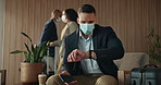 Lobby, mask and businessman with watch for work trip, thinking and waiting for convention. Travel, hotel and sick person with smartphone for check time, accommodation and safety with suitcase