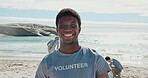 Volunteer, face and man at beach, recycling and smile for community service or cleaning with friends. Outdoor, waste management and people with plastic bag, laughing and social responsibility at sea
