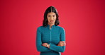 Face, angry and woman in studio, arms crossed and facial expression on red background. Space, emotional rage and person  with reaction for news, moody and upset for stress, frustrated and furious