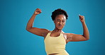 Happy, black woman and face with bicep flex in studio for fitness or power on a blue background. Portrait, female person or active model with smile, strength or showing arms for muscle gain on space