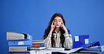 Tired, woman and documents with stress in studio for overworked pressure on a blue background. Exhausted, female person or overwhelmed with paperwork or anxiety for workload, chaos or tasks on space