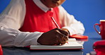 Woman, hands and writing with book in studio for schedule planning on a blue background. Closeup, female person or taking notes with diary or notebooks for deadline reminder, agenda or daily tasks 
