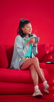 Happy woman, coffee and sofa with drink in studio for valentines day morning on a red background. Female person, relax and caffeine with mug or cup for caffeine, love or comfort on living room couch