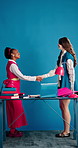 Handshake, welcome and team with business people in studio for creative consult, partner and meeting. Collaboration, shaking hands and support with women on blue background for media brand advisor