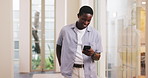 Black man, smile and reading in office with phone, text message and meme for online entertainment. Happy, person and browsing in workplace with tech, check social media or website for internet humor.