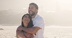 Happy couple, hug and beach with love for romance, date or travel together in nature. Man, woman or embrace with smile, sunshine or care on ocean coast for bonding, relationship or trip on seashore