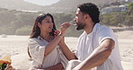 Bite, feeding and picnic with couple on beach together for anniversary, date or romance. Food, fork and sharing with happy people eating outdoor on coast for holiday, travel or vacation in summer